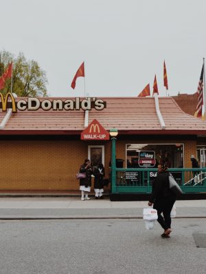 poster Une femme passant devant un fast-food