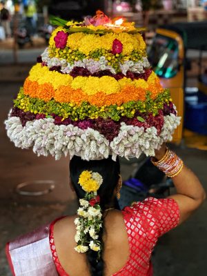 poster Une femme portant une grande composition florale sur la tête