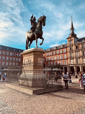 poster Statue d'un homme sur un cheval dans une cour avec des gens avec la Plaza Mayor, Madrid en arrière-plan